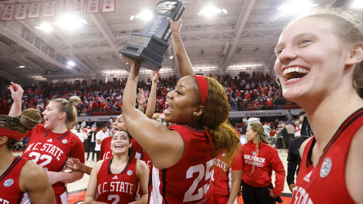 N.C. State’s Kayla Jones (25) holds up the ACC regular season champion trophy after N.C. State’s 95-53 victory over Syracuse at Reynolds Coliseum in Raleigh, N.C., Sunday, Feb. 20, 2022.