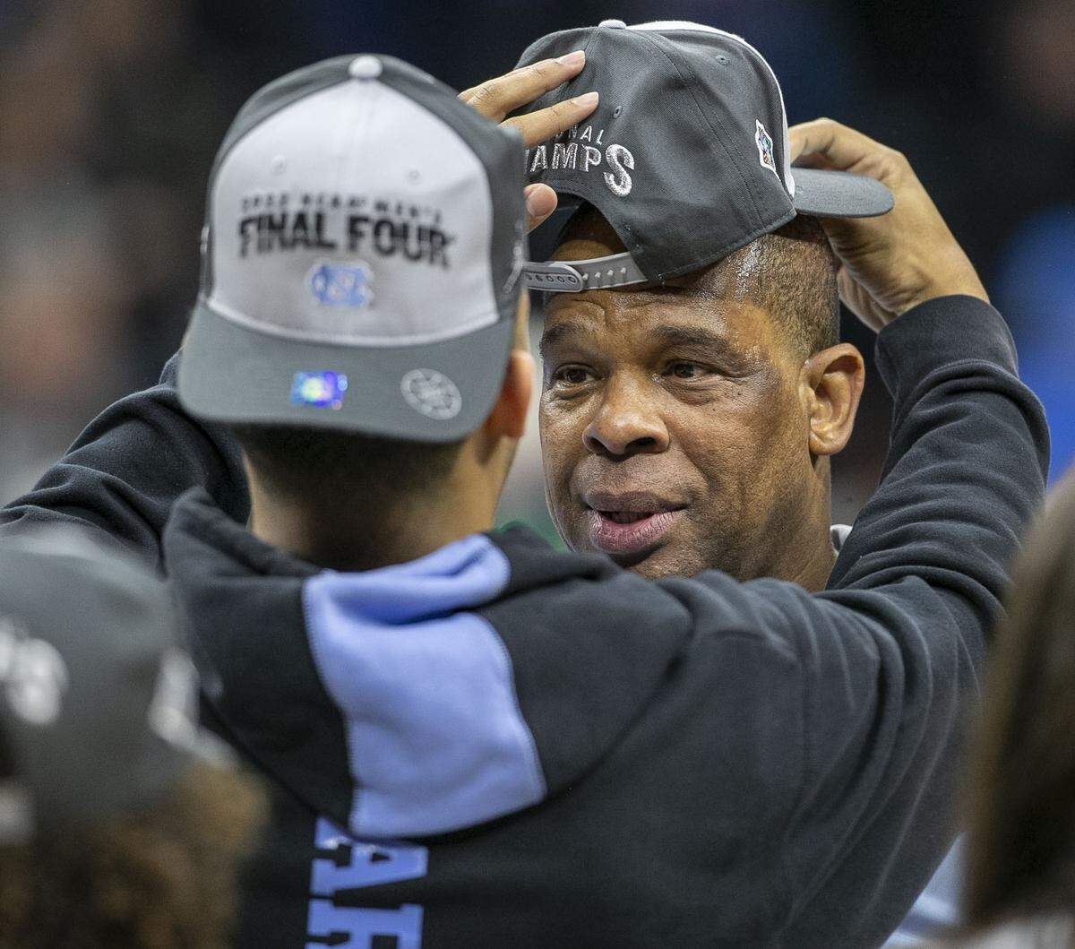 Elijah Davis adjusts his father Hubert Davis’ hat as they celebrate the Tar Heels’ victory over Saint Peter’s in the NCAA East Regional final on Sunday, March 27, 2022 at Wells Fargo Center in Philadelphia, Pa