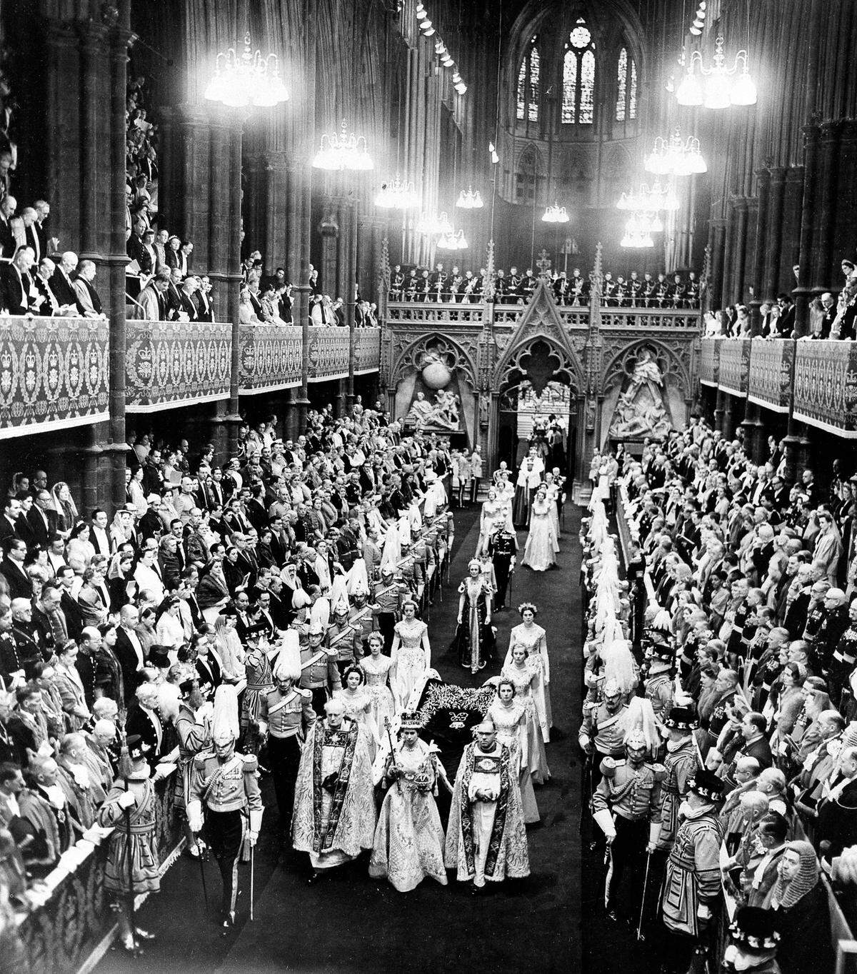 Queen Elizabeth II, wearing her crown, center foreground, leads the procession through Westminster Abbey’s nave after her coronation in London, England, June 2, 1953.