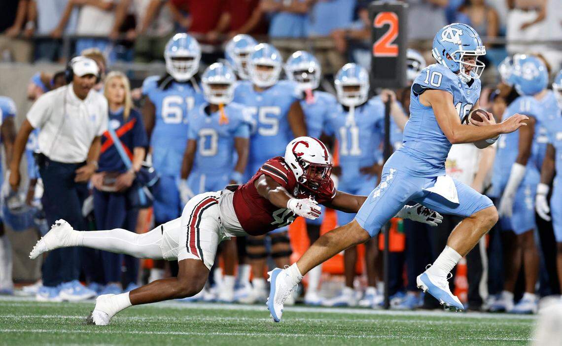 North Carolina quarterback Drake Maye (10) outruns South Carolina defensive end Bryan Thomas Jr. (46) during the first half of UNC’s game against South Carolina in the Duke’s Mayo Classic at Bank of America Stadium in Charlotte, N.C., Saturday, Sept. 2, 2023.