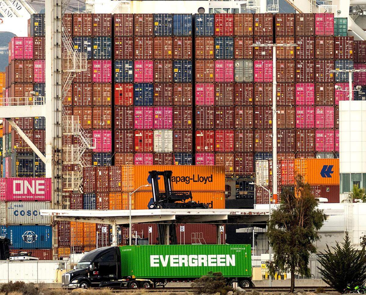 A truck passes a container ship at the Port of Oakland on Tuesday, Oct. 19, 2021, in Oakland, California.