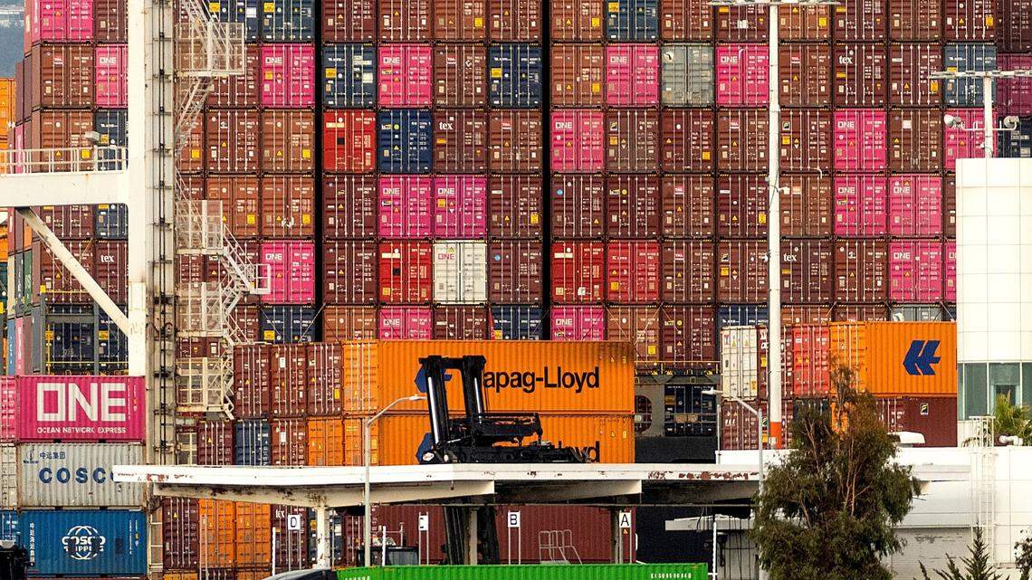 A truck passes a container ship at the Port of Oakland on Tuesday, Oct. 19, 2021, in Oakland, California.