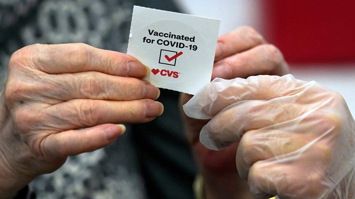 A patient receives a sticker after receiving a shot of the Moderna COVID-19 at a CVS Pharmacy branch Monday, March 1, 2021, in Los Angeles. (AP Photo/Marcio Jose Sanchez)