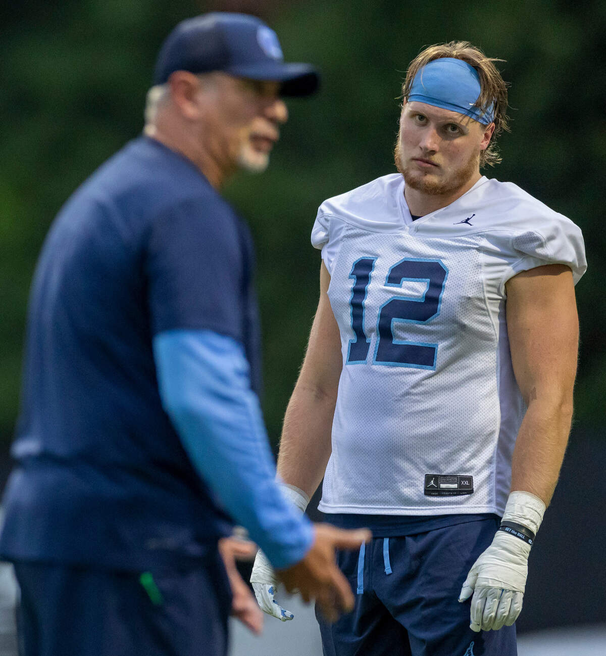 North Carolina sophomore defensive lineman Beau Atkinson (12) listens to coach Ted Monachino during the Tar Heels’ first practice of the season on Monday, July 29, 2024 in Chapel Hill, N.C.