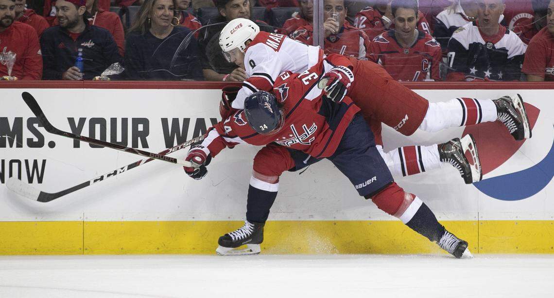 Washington Capitals’ Jonas Siegenthaler (34) checks Carolina Hurricanes’ Saku Maenalanen (8) into the boards in the first period during Game 7 of their first round Stanley Cup series on Wednesday, April 24, 2019 at Capital One Arena in Washington, D.C.