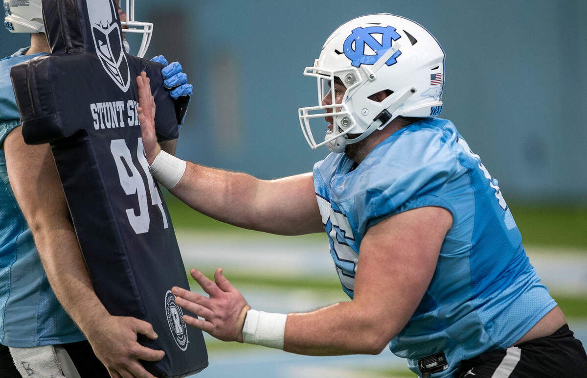 North Carolina offensive lineman Corey Gaynor (65) runs through a blocking a drill during the opening day of the Tar Heels’ spring football practice on Tuesday, March 1, 2022 in Chapel Hill, N.C.