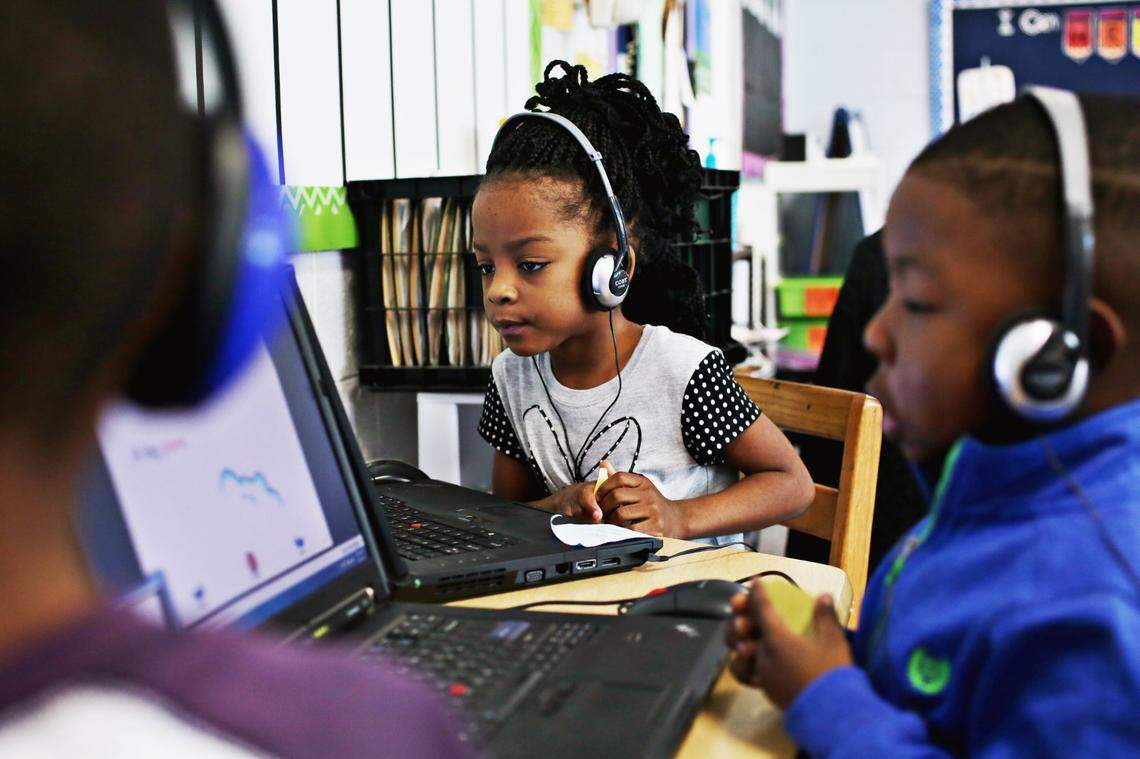 From left, kindergarteners Nasir Person, Mario Gamble and Shaniya Sanders work on their reading skills on the classroom computers at Powell Elementary School, Thursday, Jan. 5, 2017.