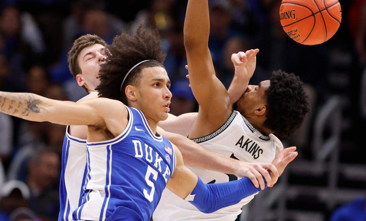 Duke’s Kyle Filipowski (30) and Tyrese Proctor (5) fight Michigan State’s Jaden Akins (3) for a rebound during the first half of Duke’s game against Michigan State in the Champions Classic at the United Center in Chicago, IL, Tuesday, Nov. 14, 2023.