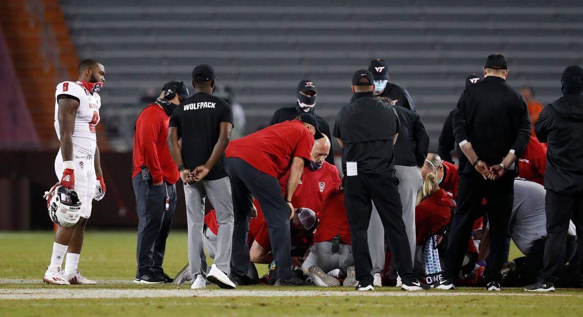 N.C. State’s Ricky Person Jr. (8), left, watches as medical staff attend to Khalid Martin during the second half of Virginia Tech’s 45-24 victory over N.C. State at Lane Stadium in Blacksburg, VA Saturday, Sept. 26, 2020.