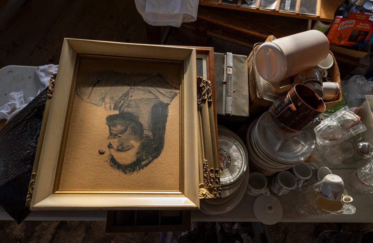 A speck of wet mud is highlighted by the evening sun on a portrait of Jesus, salvaged from the sanctuary of Old Fort United Methodist Church on Saturday, October 5, 2024 in Old Fort, N.C. More than four feet of water from Mill Creek flooded the building during Hurricane Helene.