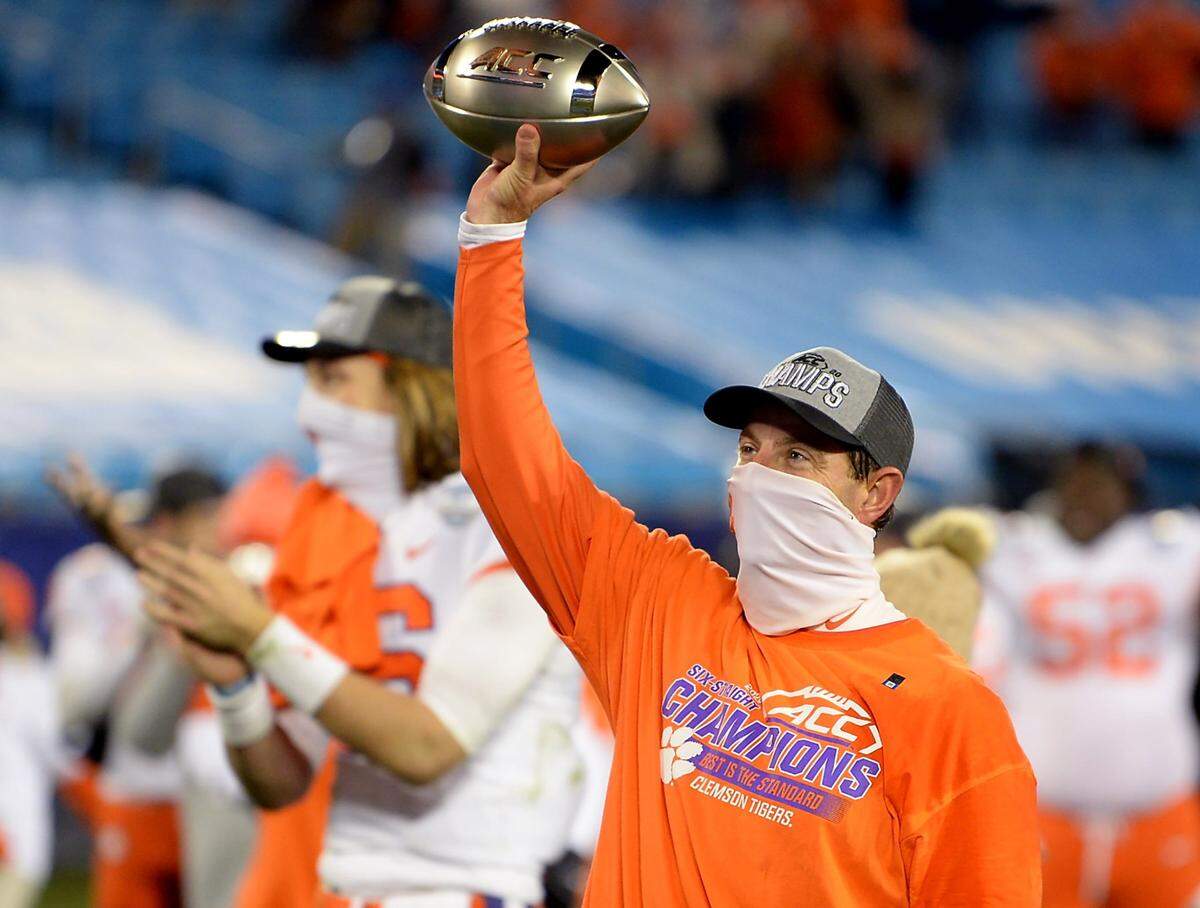 Clemson Tigers head coach Dabo Swinney holds the ACC Championship trophy in the air to the cheers of fans following the teamÕs victory over Notre Dame 34-10 at Bank of America Stadium in Charlotte, NC on Saturday, December 19, 2020.