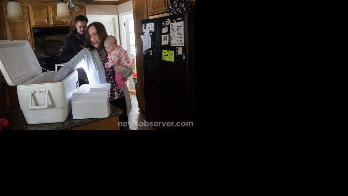 In this file photo, Max and Kate Gaskins. with their three-month-old daughter Lana, fill a cooler with perishables after their Raleigh street lost power on Feb. 26, 2015, after a winter storm dumped several inches of snow in the Triangle causing power outages and downed trees in some neighborhoods.
WXLOCAL-NE-022615-TEL