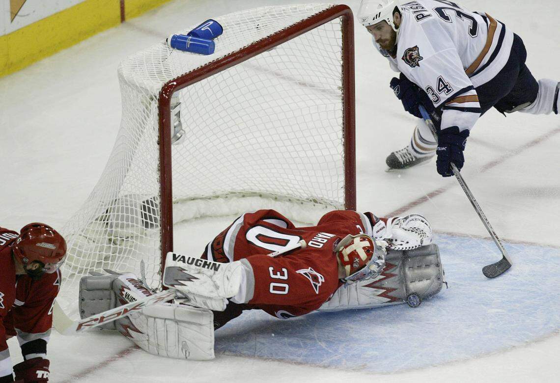 Carolina Hurricanes’ goalie Cam Ward (30), center, blocks a shot by Edmonton Oilers’ Fernando Pisani (34), right, in the third period during game 7 of the Stanley Cup Finals at the RBC Center, June 19, 2006, in Raleigh.