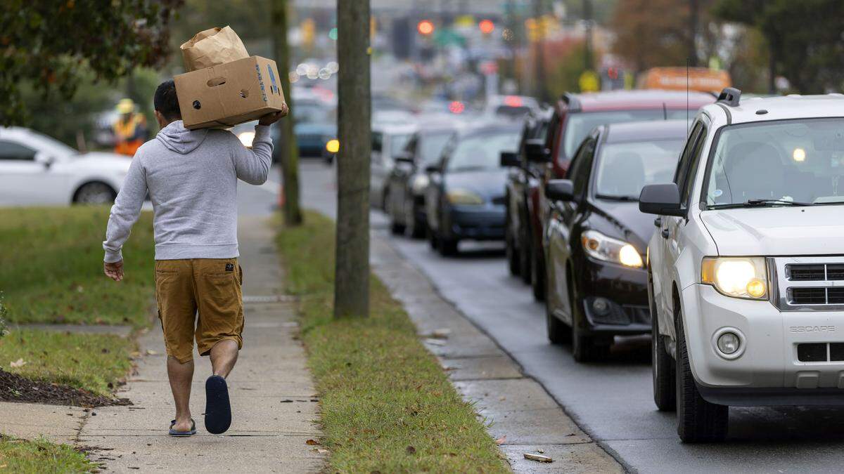 A recipient of food from the Emanuel Food Pantry at Durham Presbyterian Church, walks home with a box of groceries after visiting the weekly pantry on Roxboro Street on Wednesday, October 29, 2025, in Durham, N.C.