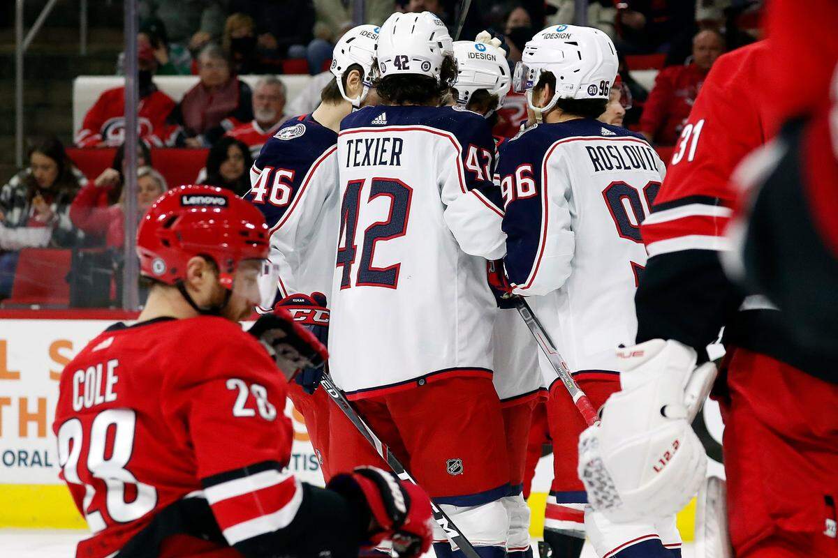 The Columbus Blue Jackets celebrate a goal by Emil Bemstrom with Carolina Hurricanes’ Ian Cole (28), foreground, during the first period of an NHL hockey game in Raleigh, N.C., Thursday, Jan. 13, 2022. (AP Photo/Karl B DeBlaker)