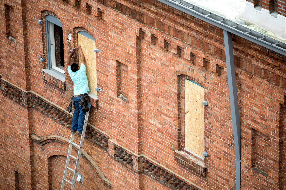 Workers board up a West Village apartment building, located across the street from where an explosion happened Wednesday, on Friday, April 12, 2019. Many of the building’s windows broke when the blast occurred.