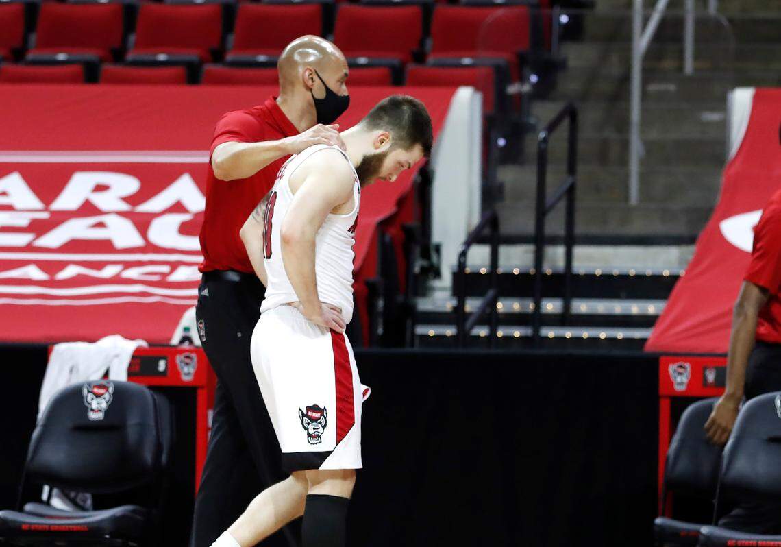 N.C. State’s Braxton Beverly (10) walks off the court with assistant coach Roy Roberson after Miami’s 64-59 victory over N.C. State at PNC Arena in Raleigh, N.C., Saturday, January 9, 2021.