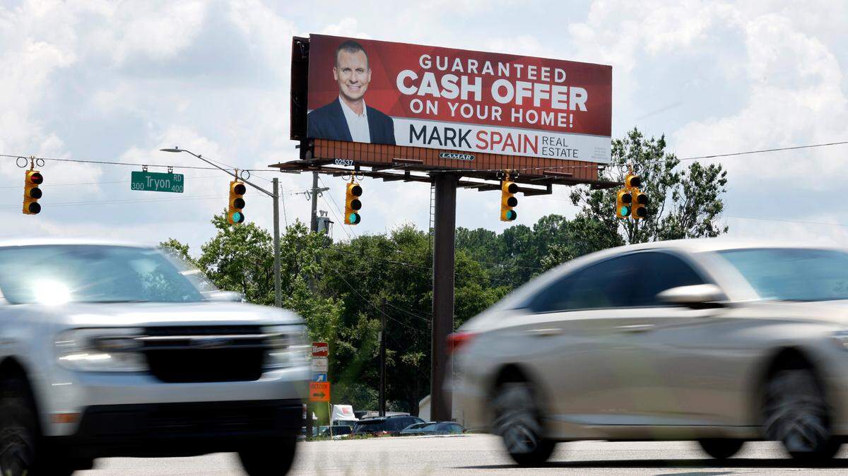 Drivers pass by a Mark Spain Real Estate billboard at the intersection of Tryon Road and S. Wilmington St. in Raleigh, N.C. Photographed Thursday, July 6, 2023.