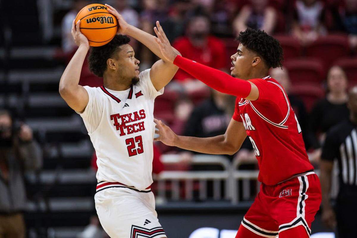 LUBBOCK, TEXAS - DECEMBER 21: Eemeli Yalaho #23 of the Texas Tech Red Raiders handles the ball against Adam Hamilton #20 of the Lamar Cardinals during the first half at United Supermarkets Arena on December 21, 2024 in Lubbock, Texas. (Photo by John E. Moore III/Getty Images)