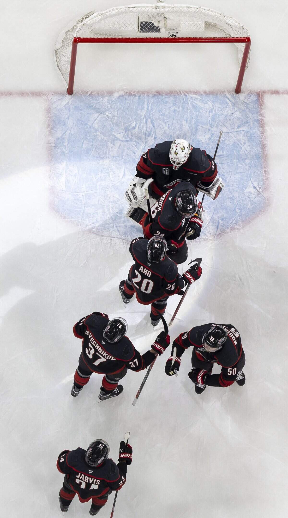 Carolina Hurricanes players line up to congratulate goalie Brandon Bussi after their 4-2 victory.