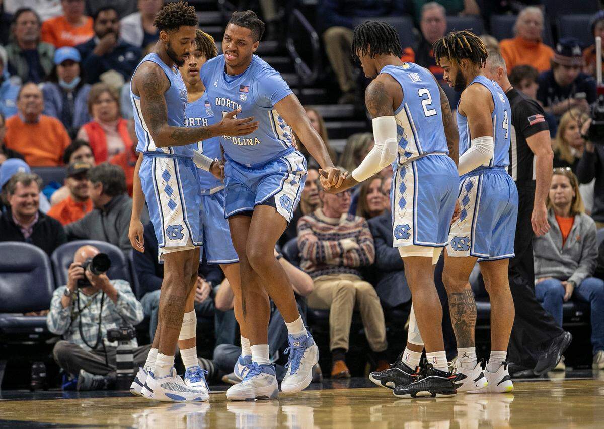 North Carolina’s Armando Bacot (5) is helped off the court after an injury in the opening minutes of play against Virginia on Tuesday, January 10, 2023 at John Paul Jones Arena in Charlottesville, Va.