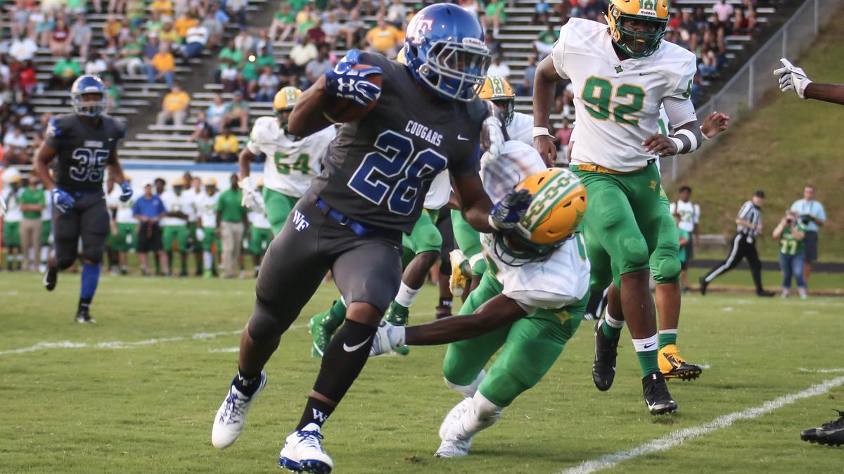 Wake Forest running back Hezekiah Foster (28) stiff-arms a Richmond defender on a long touchdown run. The Richmond Raiders played football at the Wake Forest Cougars on Friday, August 24, 2018.