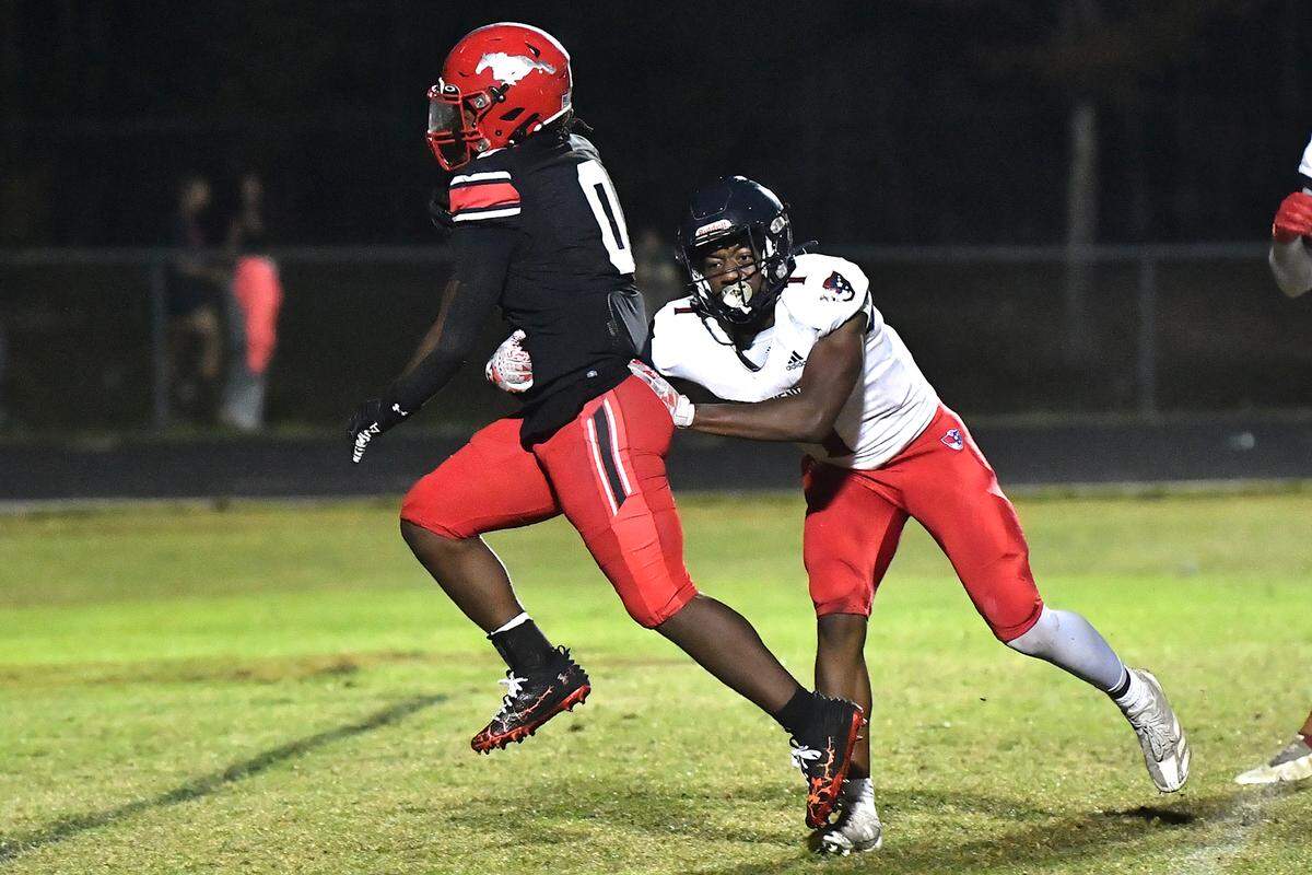 Middle Creek running back Jayden Spencer (0) runs for the touchdown against Apex Friendship’s Jayden Butler (7) during the second half. The Middle Creek Mustangs and the Apex Friendship Patriots met in a football game in Cary, N.C. on October 25, 2024.