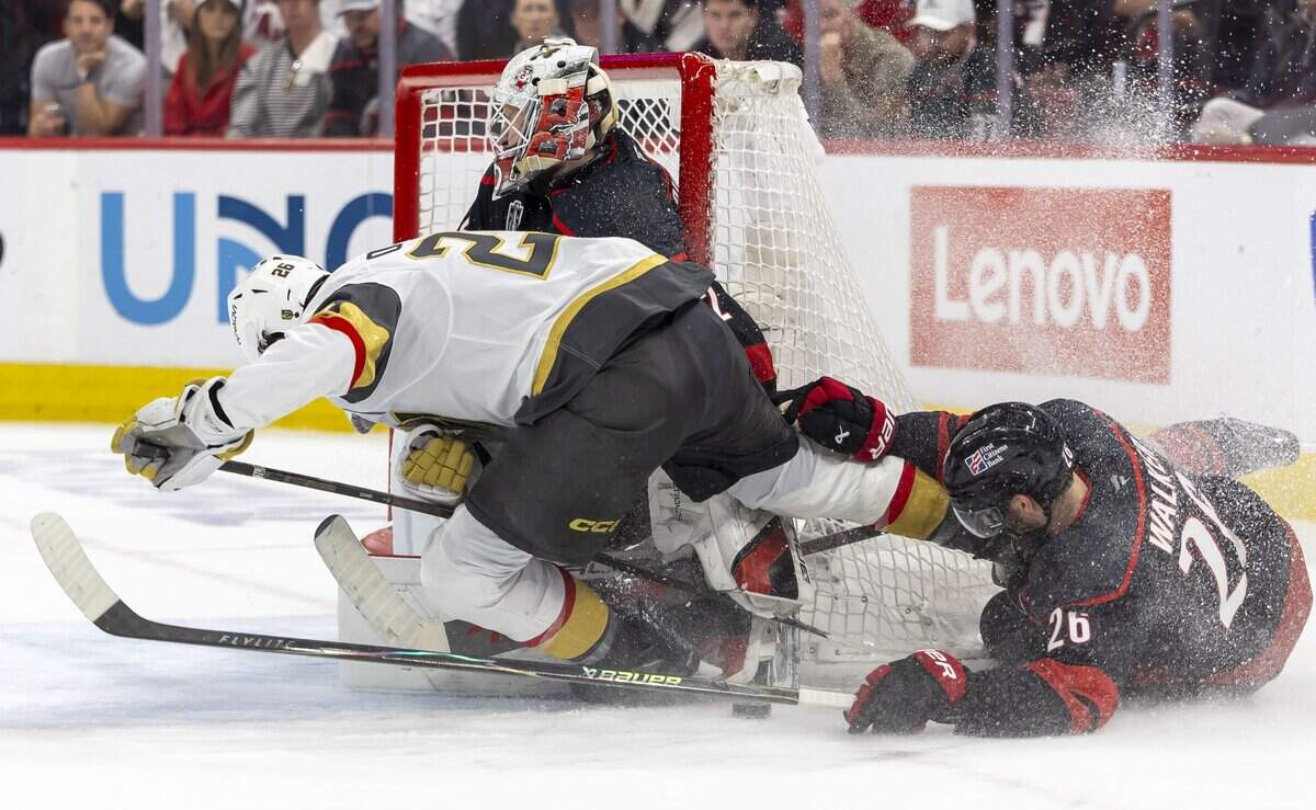 Carolina Hurricanes defenseman Sean Walker (26) collides with Vegas center Nic Dowd (26) as he works to stop a scoring attempt in front of Carolina Hurricanes goalie Brandon Bussi (32) in the second period, in Game 5 of the Stanley Cup Final against Vegas, on Thursday, June 11, 2026 at Lenovo Center in Raleigh, N.C.
