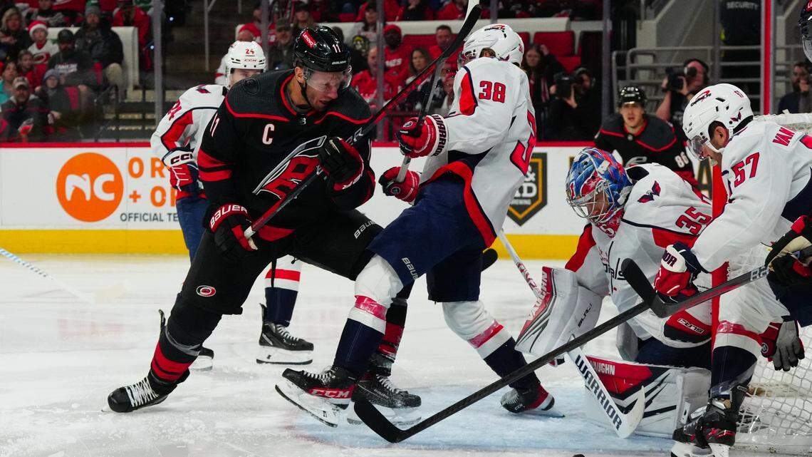 Dec 17, 2023; Raleigh, North Carolina, USA; Carolina Hurricanes center Jordan Staal (11) battles for the puck against Washington Capitals defenseman Rasmus Sandin (38) and goaltender Darcy Kuemper (35) during the first period at PNC Arena. Mandatory Credit: James Guillory-USA TODAY Sports
