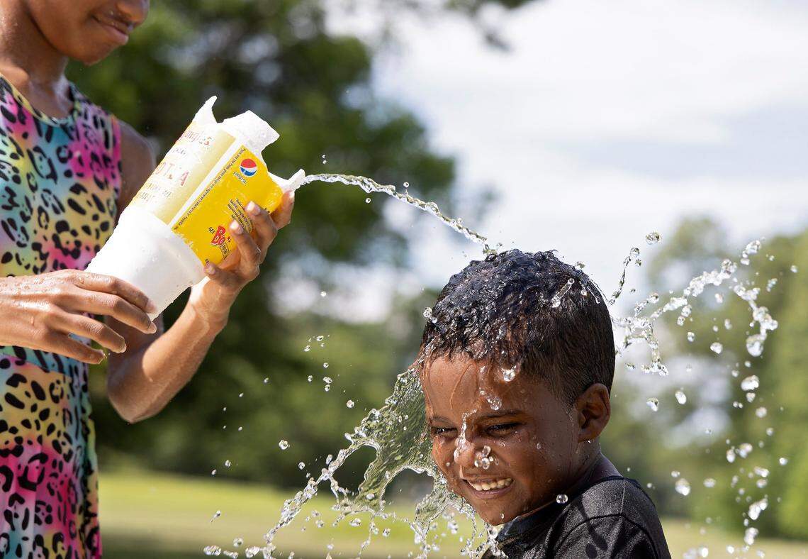 Allison Edwards, 10, pours water on Legend Hunt, 6, at Forest Hills Park on Monday, July 3, 2023, in Durham, N.C. Temperatures are expected to reach the mid-90s with a heat index in the triple digits this week in the Triangle.