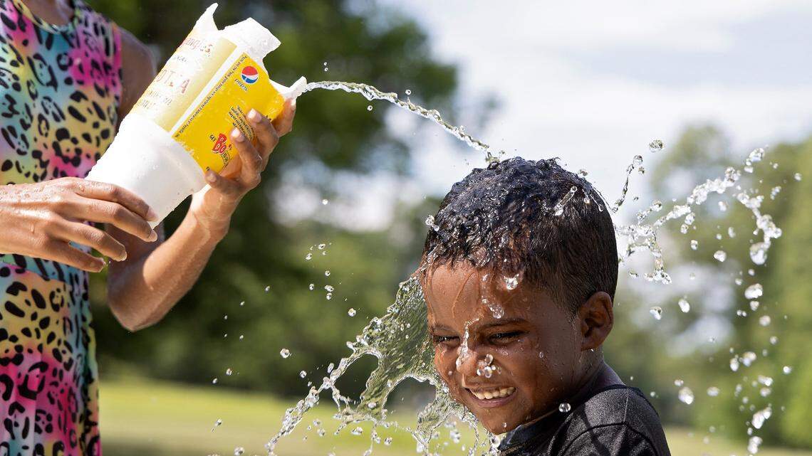Allison Edwards, 10, pours water on Legend Hunt, 6, at Forest Hills Park on Monday, July 3, 2023, in Durham, N.C. Temperatures are expected to reach the mid-90s with a heat index in the triple digits this week in the Triangle.