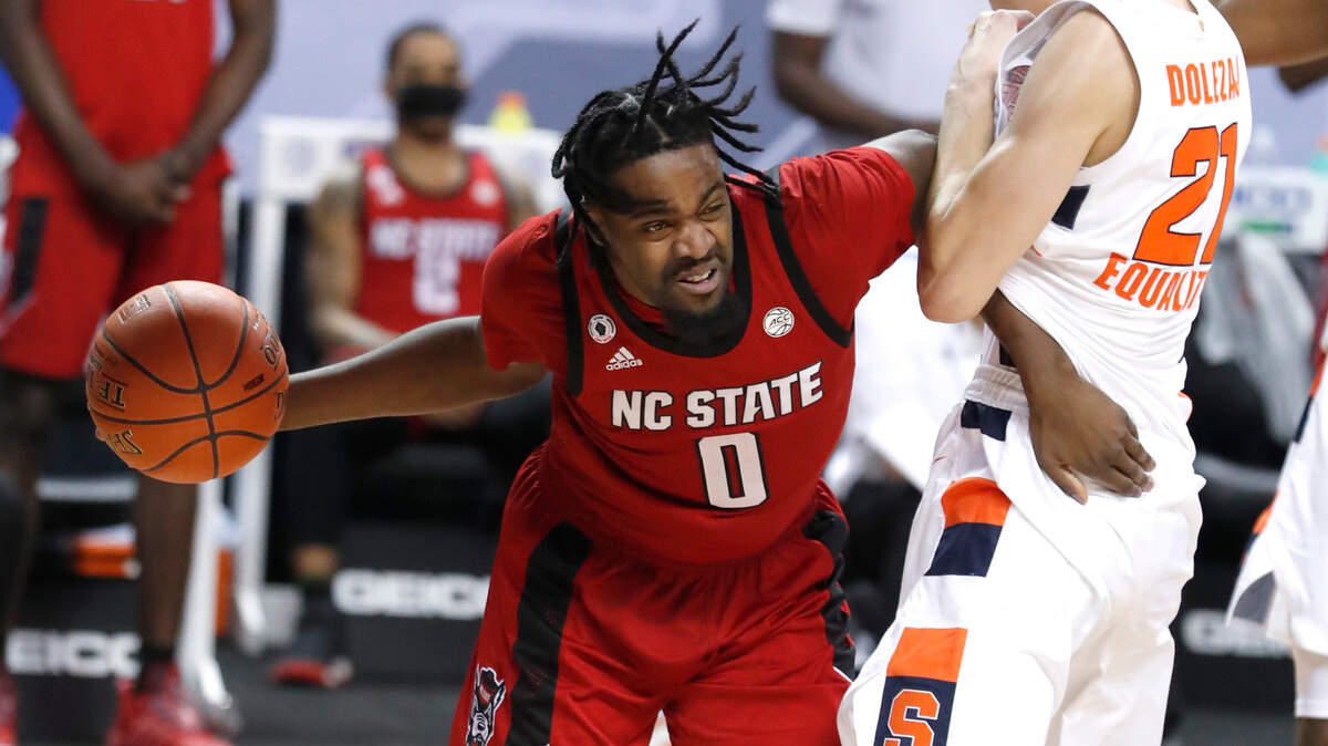 N.C. State’s D.J. Funderburk (0) drives around Syracuse’s Marek Dolezaj (21) during the second half of Syracuse’s 89-68 victory over N.C. State in the second round of the ACC Men’s Basketball Tournament in Greensboro, N.C., Wednesday, March 10, 2021.