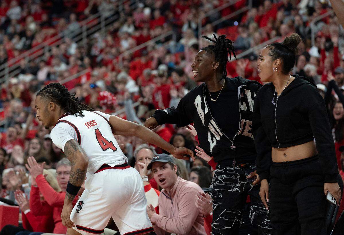 N.C. State’s Breon Pass is congratulated by women’s basketball players Saniya Rivers and Madison Hayes after knocking down a three-pointer during the first half of the Wolfpack’s 84-74 overtime win over Florida State on Saturday, Dec. 7, 2024, at Lenovo Center in Raleigh, N.C.