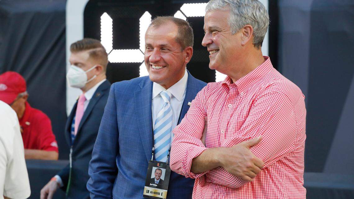 ACC commissioner Jim Phillips talks with N.C. State athletic director Boo Corrigan before the Wolfpack’s game against Miami at Hard Rock Stadium in Miami Gardens, Fla. Saturday, Oct. 23, 2021.