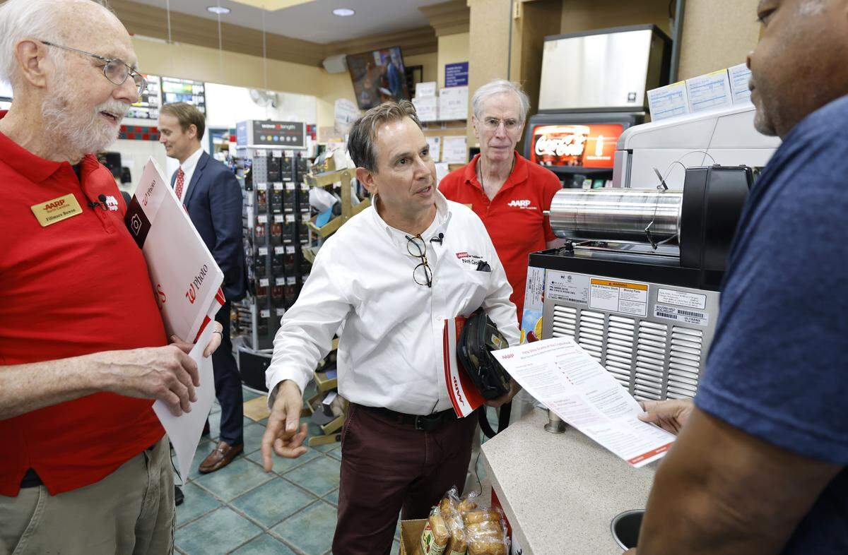 Steve Hahn with the AARP talks to a manager of a convenience store in Cary asking if they could put up an educational poster near their crypto ATM machine Tuesday, May 12, 2026.