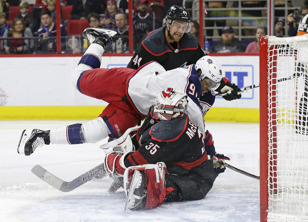 Carolina Hurricanes goalie Curtis McElhinney (35) blocks Columbus Blue Jackets’ Anthony Duclair (91) while Hurricanes’ Calvin de Haan (44) watches during the first period of an NHL hockey game in Raleigh, N.C., Friday, Jan. 4, 2019. (AP Photo/Gerry Broome)