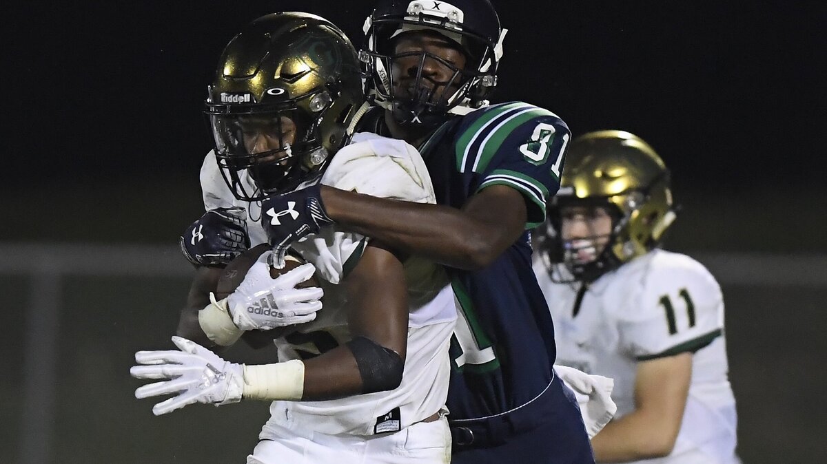 Jacob Gill, left, of Cardinal Gibbons carries the ball against a tackle from Jalen Kimball (81) of Leesville Road. The Cardinal Gibbons Crusaders visited the Leesville Road Pride in a high school football game on September 21, 2018. Cardinal Gibbons won 33-22.