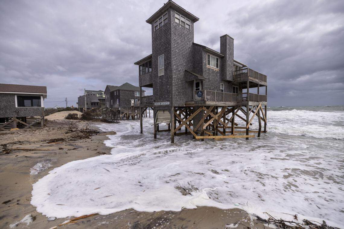 Rough surf threatens beach homes during high tide in Buxton Friday morning.