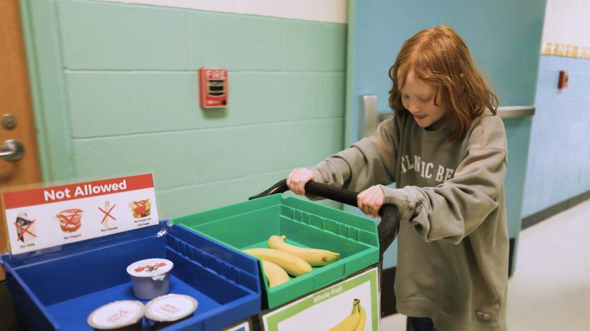 A Wake County student pushes a cart in the SHARE (Stop Hunger and Restore Earth) program. The Wake County school system and Towards Zero Waste have partnered in a program to recover unopened packages of food that can be given to students to eat.