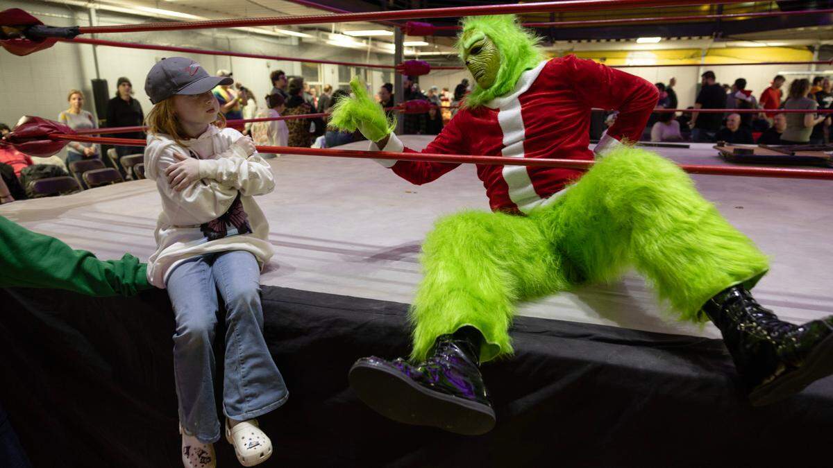 Wrestling fan Emeline Leazer, 8, throws some attitude at The Grinch after the man in green was defeated by Santa at FWE Merry Mayhem in Cary, N.C., Saturday night, Dec. 14, 2024.