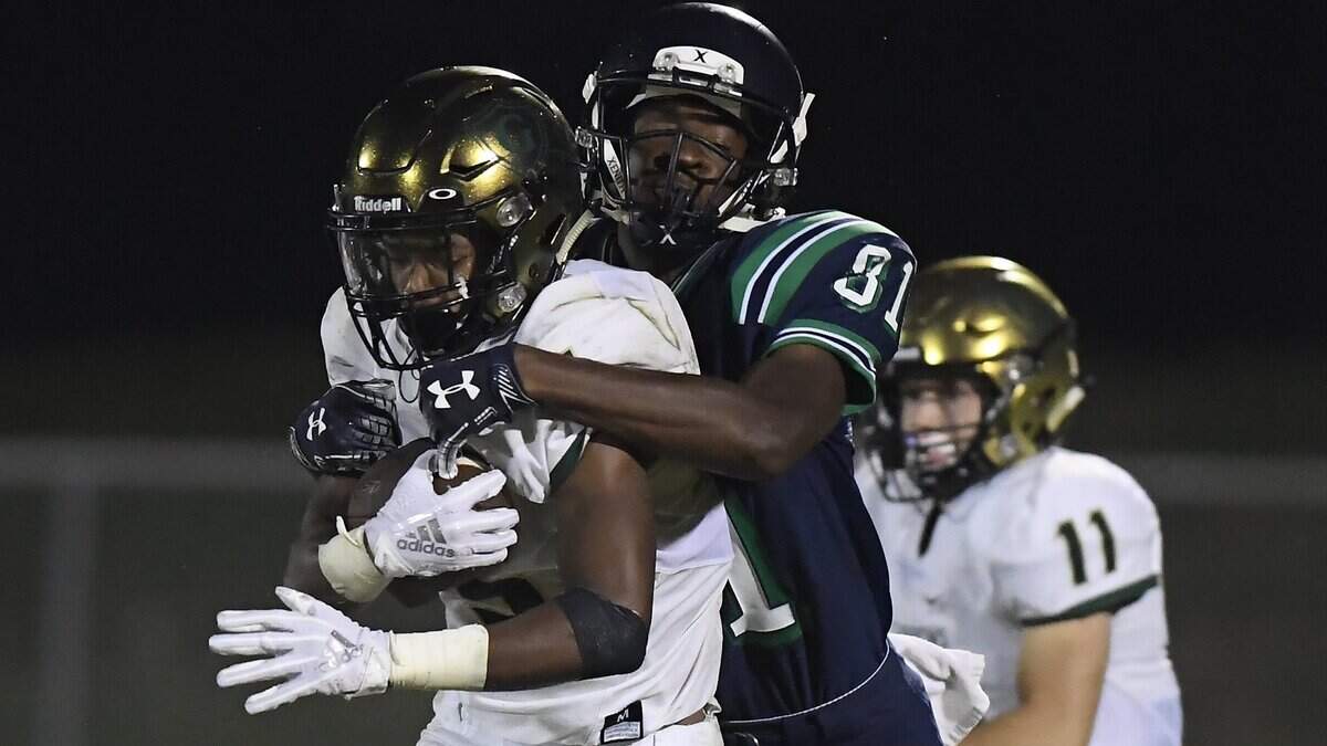 Jacob Gill, left, of Cardinal Gibbons carries the ball against a tackle from Jalen Kimball (81) of Leesville Road. The Cardinal Gibbons Crusaders visited the Leesville Road Pride in a high school football game on September 21, 2018. Cardinal Gibbons won 33-22.