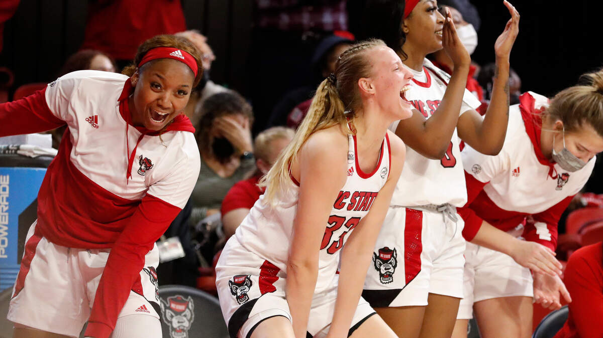 N.C. State’s Kayla Jones, left, Elissa Cunane and Jada Boyd celebrate a basket by Jessica Timmons during the second half of N.C. State’s 72-45 victory over UNC at Reynolds Coliseum in Raleigh, N.C., Thursday, January 6, 2022.