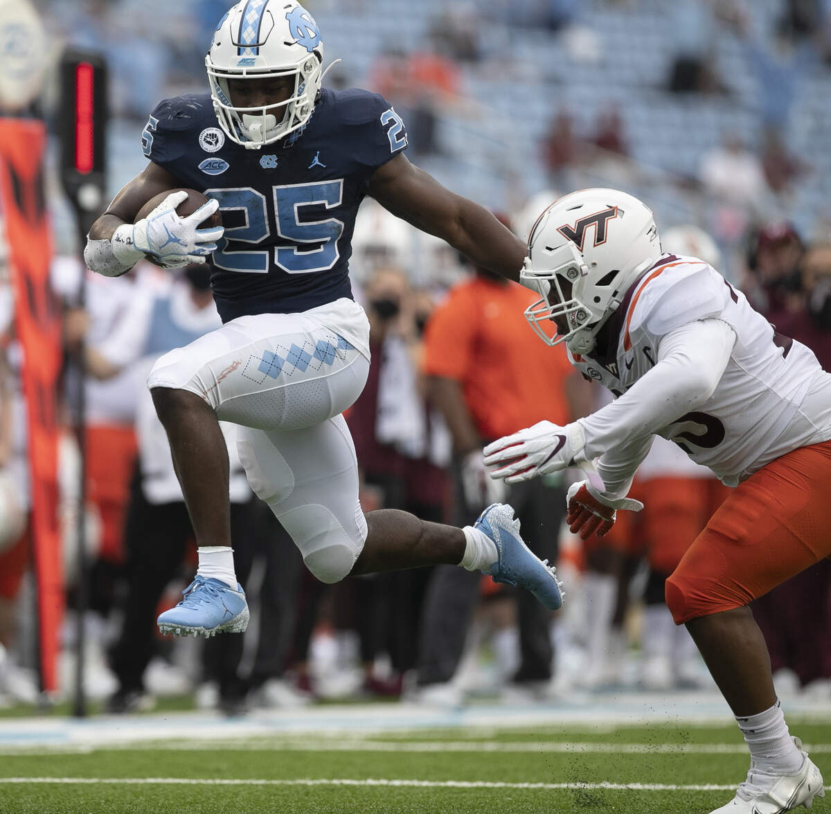 North Carolina’s Javonte Williams (25) breaks away from Virginia Tech’s Rayshard Ashby (23) on a 19-yard run for a touchdown to give the Tar Heels’ a 21-0 lead on Saturday, October 10, 2020 at Kenan Stadium in Chapel Hill, N.C.