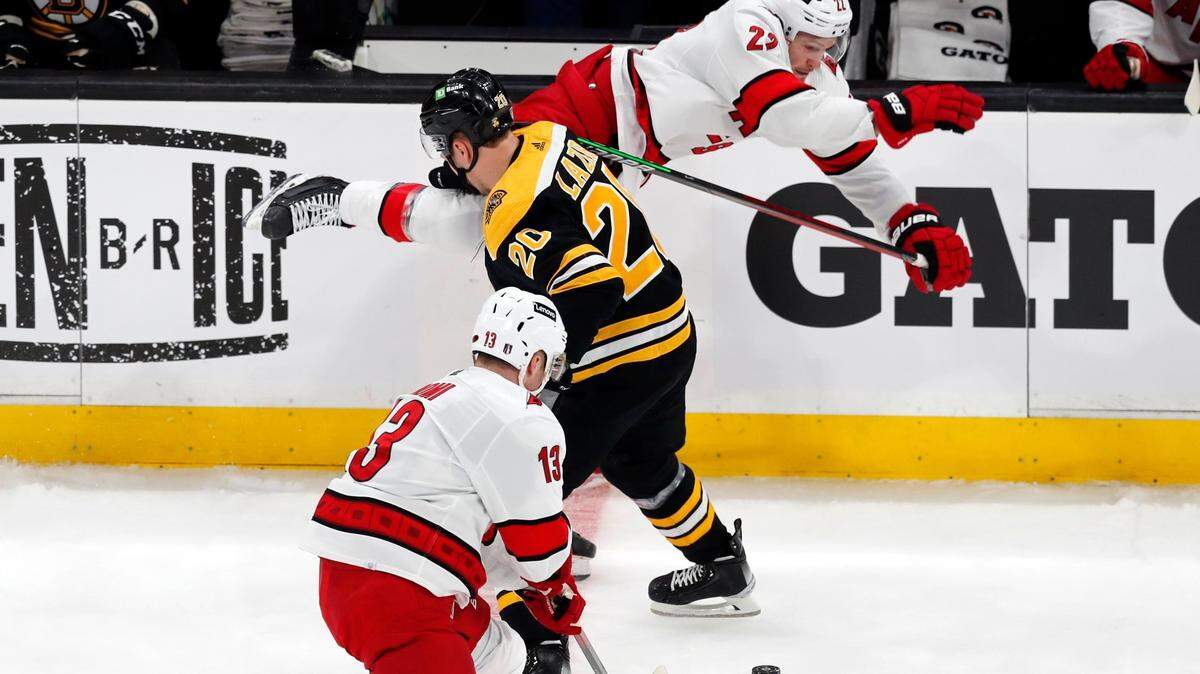 Boston Bruins’ Curtis Lazar (20) checks Carolina Hurricanes’ Brett Pesce (22) during the first period of Game 3 of an NHL hockey Stanley Cup first-round playoff series, Friday, May 6, 2022, in Boston. (AP Photo/Michael Dwyer)