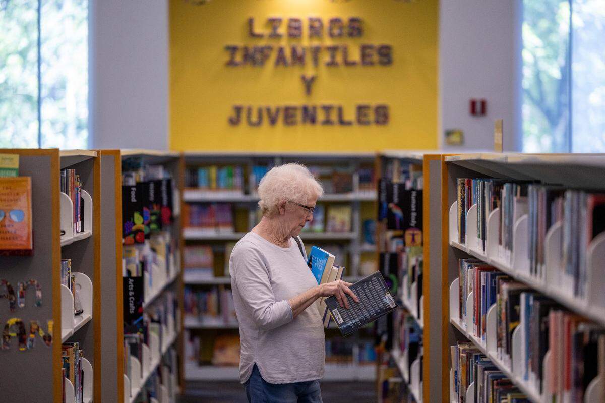 Jeri Lewis looks for books to check out at the Green Road Library in Raleigh on Tuesday, May 22, 2024.