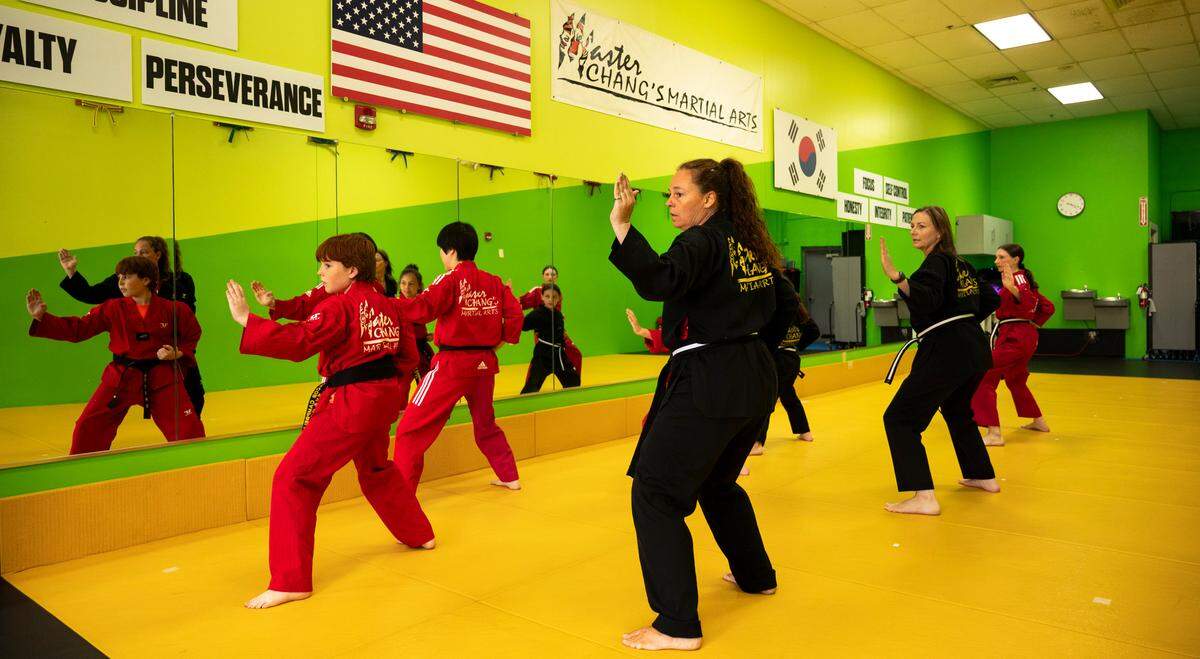 Laura Campbell and Sherri Smith practice taekwondo with their kids led by instructor Gawon Lee at Master Chang’s Martial Art Studio in Durham, N.C. on June 4, 2024. Smith has been Campbell’s sparring partner and companion through their journey to earn their black belts.