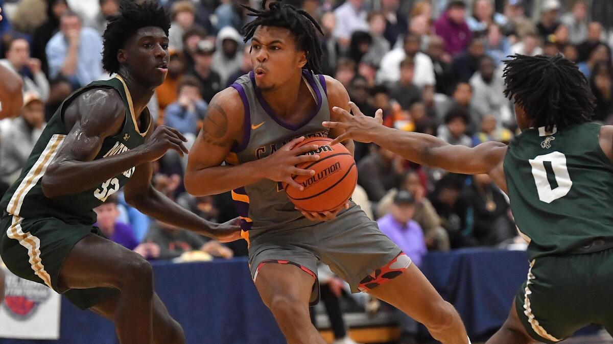 Camden’s DJ Wagner (21) drives to the basket against Northwood’s Drake Powell (32) and Frederico Whitaker Jr. during the first half. The Camden (NJ) Panthers and the Northwood Chargers met in the John Wall Holiday Invitational in Raleigh, N.C. on December 28,2022 .