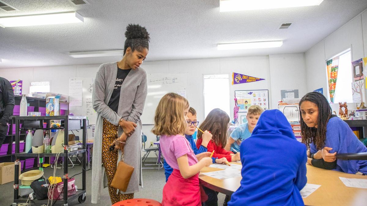 Parent Meka Harrell, left, visits a first-grade classroom during a February 2020 tour of Exploris School, a public charter elementary school in Raleigh. The tour took place during the school's open application period for prospective families. 