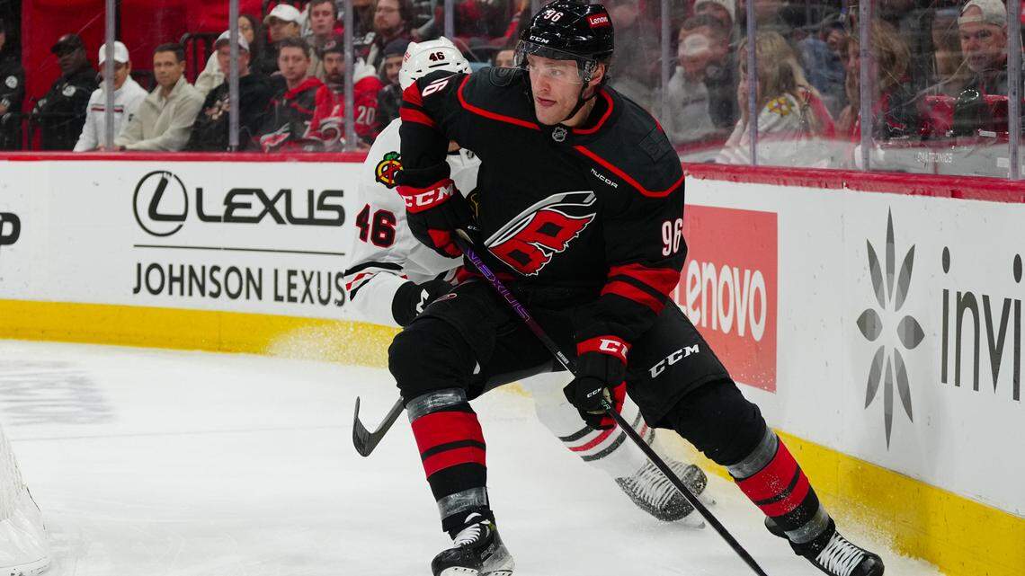 Jan 30, 2025; Raleigh, North Carolina, USA; Carolina Hurricanes right wing Mikko Rantanen (96) skates with the puck past Chicago Blackhawks defenseman Louis Crevier (46) during the first period at Lenovo Center. James Guillory-Imagn Images