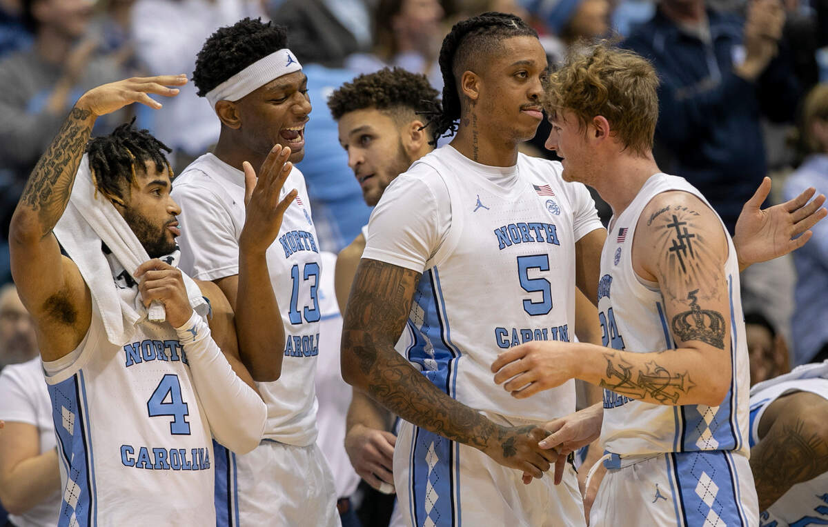 North Carolina’s R.J. Davis (4), Jalen Washington (13) and Armando Bacot (5) greet Tyler Nickel (24) as he comes out of the game after scoring 16 points against The Citadel on Tuesday, December 13, 2022 at the Smith Center in Chapel Hill, N.C.